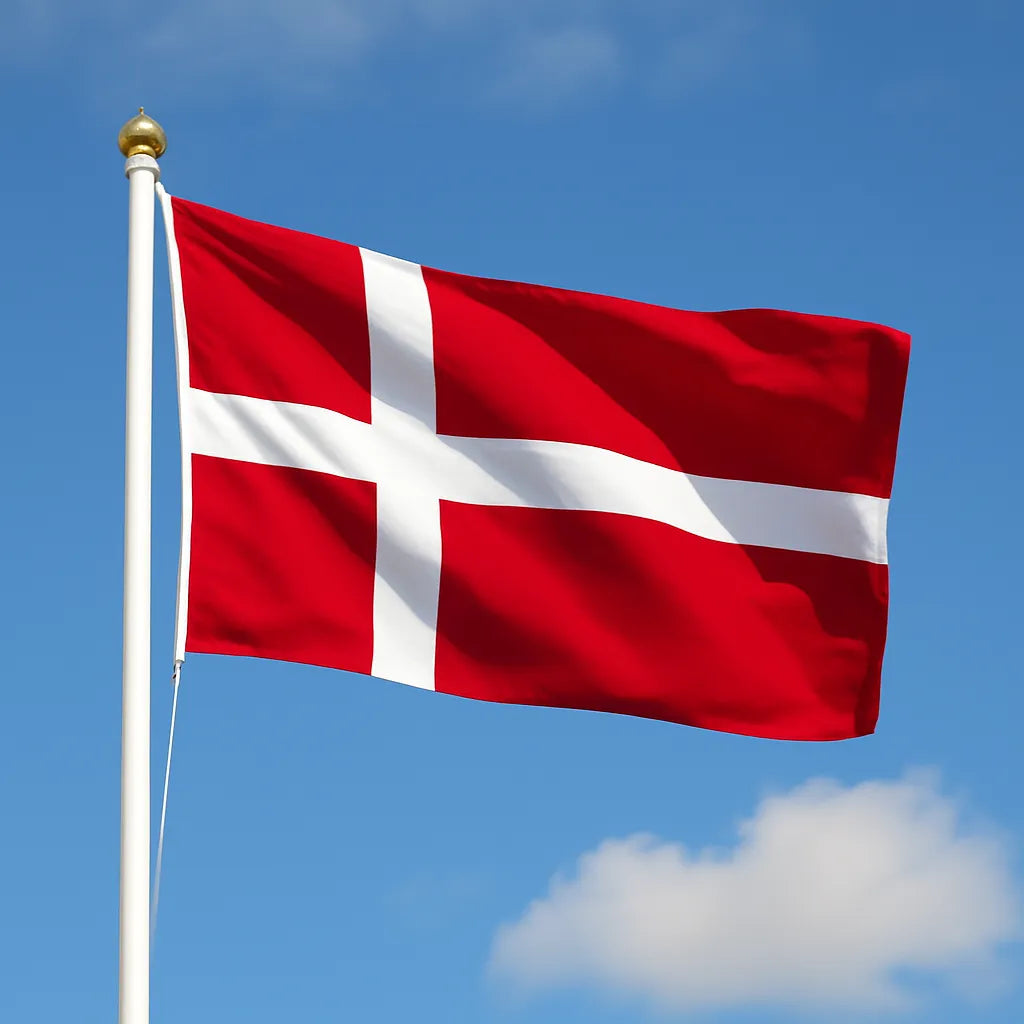 Denmark Flag flying on a flagpole with a blue sky