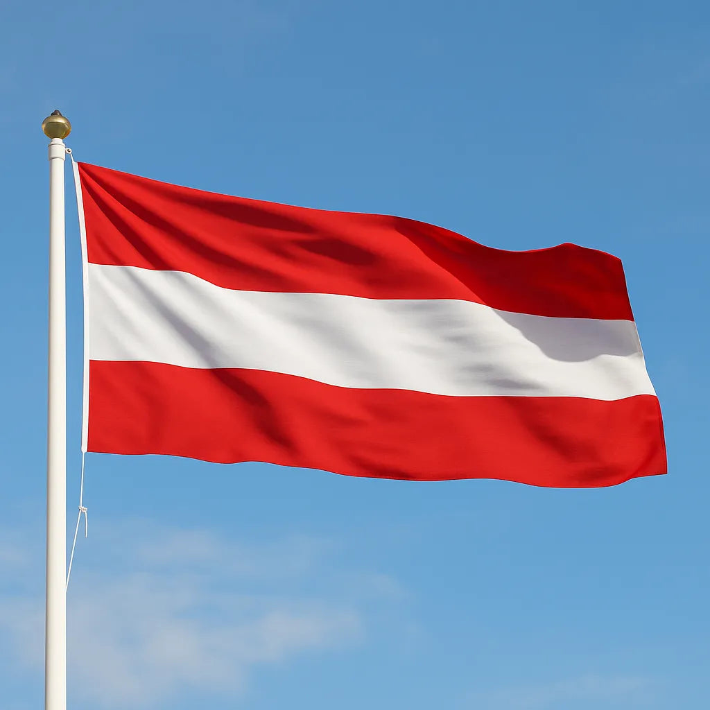 High-quality sewn Austria flag flying on an outdoor flagpole against a blue sky.