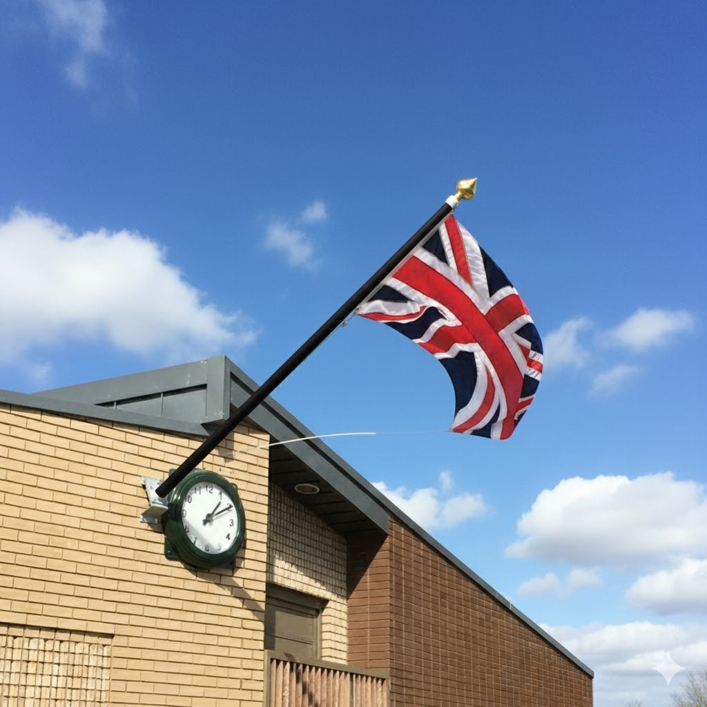Black flagpole with a gold finial flying the union jack flag.