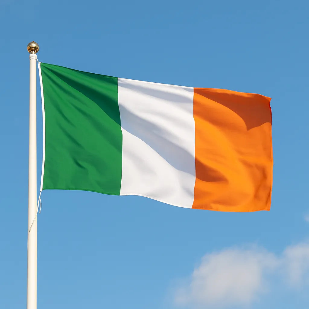 Irish flag waving against a clear blue sky with a few clouds.