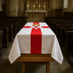 coffin drape with a red and white design  flag in a church setting