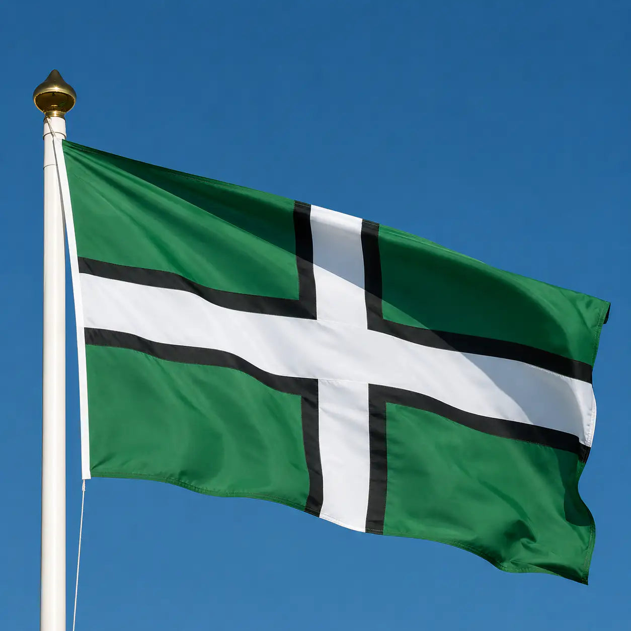 The Devon flag flying on a flagpole with a blue sky in the background