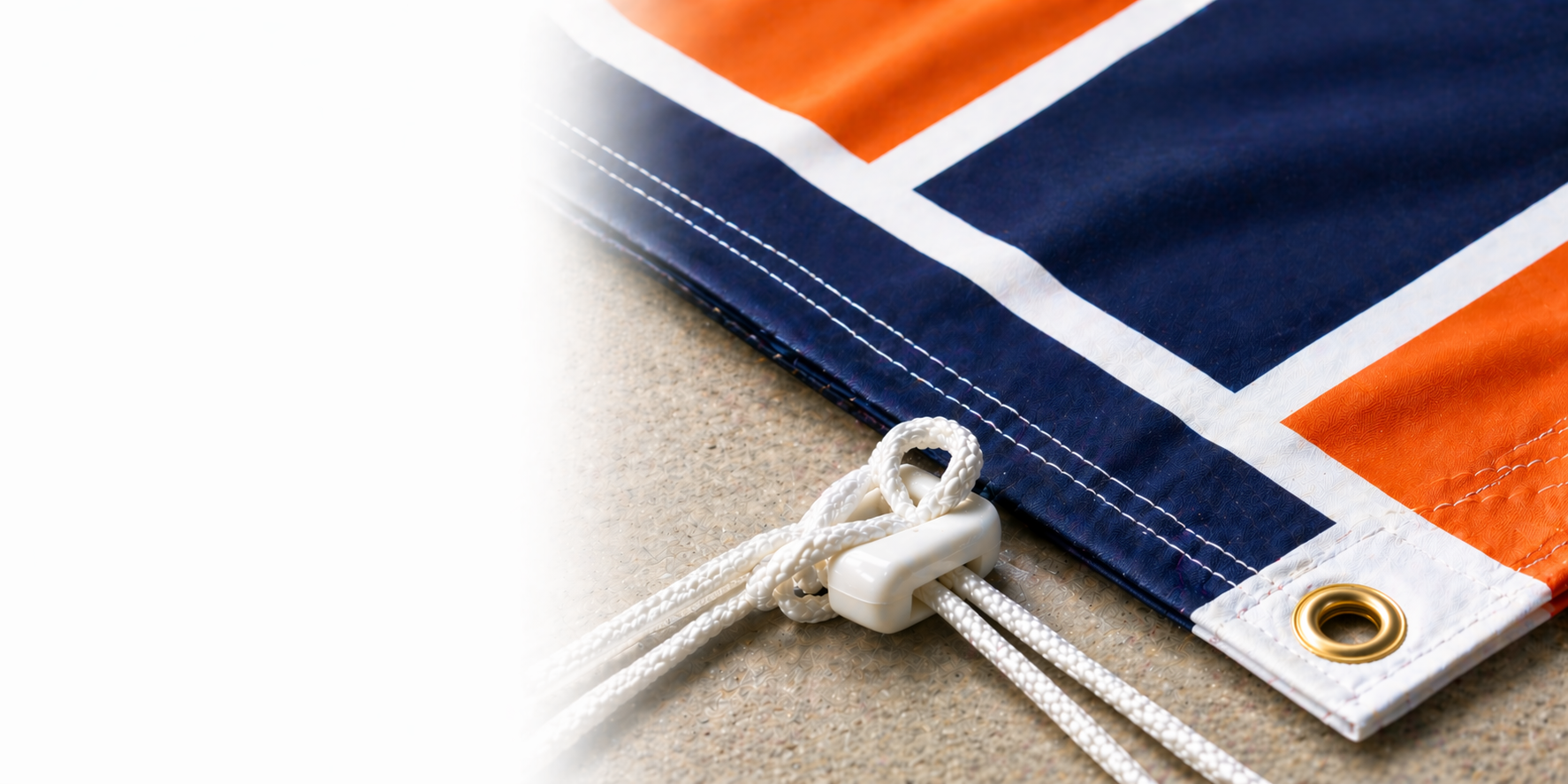 Close-up of a flag with orange, blue, and white colors on a textured surface.