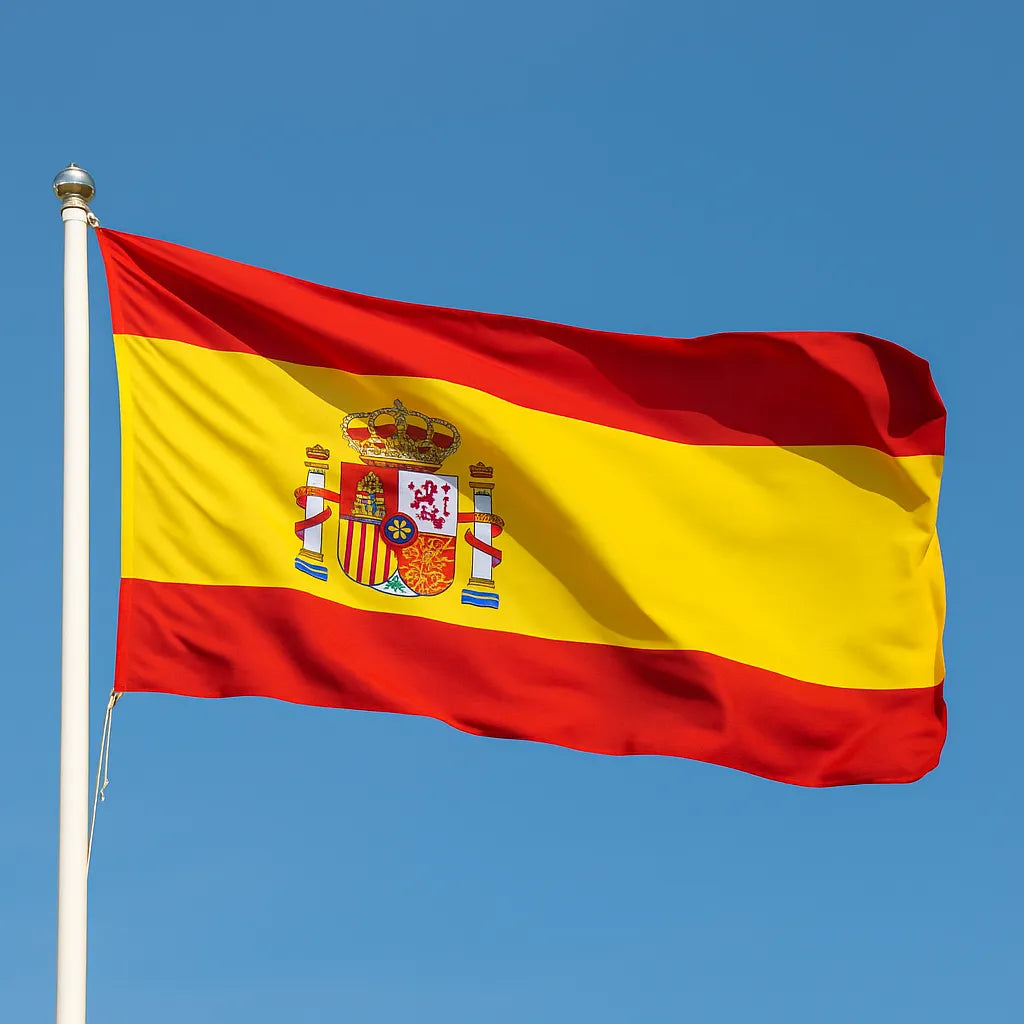 Spanish flag with coat of arms against a clear blue sky